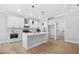A bright kitchen featuring white cabinets and an island with seating and stainless appliances at 1429 Sagamore Dr, Louisburg, NC 27549