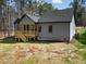 The back of the home has gray siding and a wooden porch with stairs leading down to the yard at 1429 Sagamore Dr, Louisburg, NC 27549