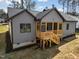 The back of the home has gray siding and a wooden porch with stairs leading down to the yard at 1429 Sagamore Dr, Louisburg, NC 27549