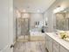 Bright bathroom features a walk-in shower, soaking tub, double vanity, and neutral tile at 1505 Bright Coral Trl, Wendell, NC 27591