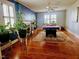 Living room featuring hardwood floors, a pool table, fireplace, and large windows at 1522 W Thomas St, Rocky Mount, NC 27804