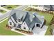 Striking aerial shot of a home showcasing a unique roofline, painted brick exterior, and manicured lawn at 1801 Clifton Pines Dr, Cary, NC 27519