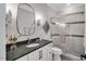 Modern bathroom featuring a glass shower door, large mirror, granite countertop and white vanity at 1801 Clifton Pines Dr, Cary, NC 27519