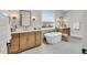Bright bathroom featuring double vanities, a soaking tub, and herringbone tile flooring at 1801 Clifton Pines Dr, Cary, NC 27519