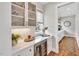 Chic butler's pantry featuring glass-front cabinets, quartz countertops, a wine fridge, and modern fixtures at 1801 Clifton Pines Dr, Cary, NC 27519