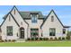 Stunning two-story white brick home with a manicured lawn and a welcoming front entrance with an arched doorway at 1801 Clifton Pines Dr, Cary, NC 27519