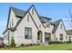 Beautiful two-story brick home featuring manicured landscaping and a charming covered front porch area with red chairs at 1801 Clifton Pines Dr, Cary, NC 27519