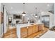 Open-concept kitchen with a large island flowing into the living room and fireplace at 1801 Clifton Pines Dr, Cary, NC 27519