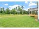 Large green backyard with trees and a deck overlooking the yard at 20 Bold Dr, Youngsville, NC 27596