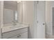 Bathroom with a white vanity, white basin, large mirror, and white doors at 20 Bold Dr, Youngsville, NC 27596