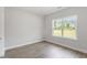 Comfortable bedroom with wood-look flooring, neutral paint and a large window at 20 Bold Dr, Youngsville, NC 27596