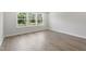 Empty bedroom showing light hard wood floors, one window and white walls at 20 Bold Dr, Youngsville, NC 27596