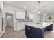 Modern kitchen with white cabinets, a navy island with sink, stainless appliances, and stylish backsplash at 20 Bold Dr, Youngsville, NC 27596