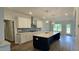 Bright kitchen with large island, stainless appliances and fixtures, with view to the back patio at 20 Bold Dr, Youngsville, NC 27596