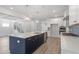 Bright, open kitchen with a navy island, white cabinets, stainless steel appliances, and stylish pendant lighting at 20 Bold Dr, Youngsville, NC 27596