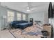 Bedroom featuring a ceiling fan, blue sofa, TV, and lots of natural light at 2021 Terri Creek Dr, Fuquay Varina, NC 27526