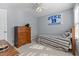 This bedroom features light gray walls, a ceiling fan, a sports banner, and a comfortable bed with striped bedding at 2021 Terri Creek Dr, Fuquay Varina, NC 27526