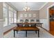 Dining room featuring a dark wooden table, bench, natural light, chandelier, and wainscoting at 2021 Terri Creek Dr, Fuquay Varina, NC 27526