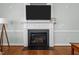 Elegant fireplace with white mantel, black hearth, and mounted television in a naturally lit room at 2021 Terri Creek Dr, Fuquay Varina, NC 27526