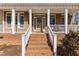 Inviting brick home featuring a charming front porch and a classic wooden door with decorative wreath at 2021 Terri Creek Dr, Fuquay Varina, NC 27526