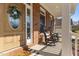 Inviting front porch with brick accents, rocking chairs, and a charming front door with a decorative wreath at 2021 Terri Creek Dr, Fuquay Varina, NC 27526