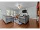 Bright living room with hardwood floors, fireplace, ceiling fan and ample natural light from large windows at 2021 Terri Creek Dr, Fuquay Varina, NC 27526