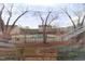 View of the community pool with a black metal fence viewed through bare winter trees at 2500 Friedland Pl # 101, Raleigh, NC 27617