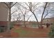 Exterior view of community pool and manicured landscape, lined with trees at 2500 Friedland Pl # 101, Raleigh, NC 27617