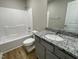 Well-lit bathroom with a granite-topped vanity, a mirror, and a shower-tub combo at 255 Constellation Ct, Benson, NC 27504