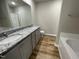 Bathroom featuring a double vanity with granite countertops and wood-look vinyl flooring at 255 Constellation Ct, Benson, NC 27504