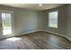 Bright bedroom with a wood-look floor, white trim and window, and a glass door leading to the outside at 255 Constellation Ct, Benson, NC 27504