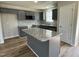 Stylish gray kitchen with a granite-topped island, modern appliances, and wood-look floors at 255 Constellation Ct, Benson, NC 27504