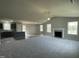 Spacious living room with plush carpeting, fireplace, ceiling fan, and ample natural light filtering through multiple windows at 255 Constellation Ct, Benson, NC 27504