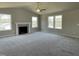Large, neutral living room with carpet, ceiling fan, fireplace, and lots of windows for natural light at 255 Constellation Ct, Benson, NC 27504