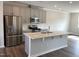 Spacious kitchen featuring stainless appliances, a center island, shaker style cabinets, and hardwood floors at 3007 Honeymyrtle Ln, Durham, NC 27703