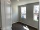 Well-lit bedroom showcasing dark floors, neutral walls, and two windows offering a pleasant view of the outside at 3012 Honeymyrtle Ln, Durham, NC 27703