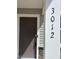 Close-up of the front door featuring the house number and a modern electronic lock for added security and convenience at 3012 Honeymyrtle Ln, Durham, NC 27703