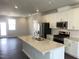 Open-concept kitchen featuring white cabinets, quartz countertops, stainless steel appliances, and dark hardwood flooring at 3012 Honeymyrtle Ln, Durham, NC 27703