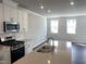Bright, modern kitchen with stainless steel appliances, a gas range, and an island that opens into a spacious living area at 3012 Honeymyrtle Ln, Durham, NC 27703