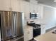 Modern kitchen with stainless steel appliances, subway tile backsplash, and white cabinetry, offering a sleek and functional space at 3012 Honeymyrtle Ln, Durham, NC 27703
