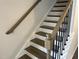 Elegant staircase with dark wood treads, white risers, and a decorative handrail at 3012 Honeymyrtle Ln, Durham, NC 27703