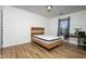 Bright bedroom with hardwood style floors, a window, and a modern bed frame at 3031 Winston Dr # Apt 302, Burlington, NC 27215