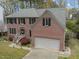 Aerial view of a two-story brick home with an attached garage and established landscaping at 3416 Cottonwood Dr, Durham, NC 27707