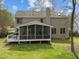 Two-story home with a screened in porch and deck overlooking the large backyard with green grass at 3416 Cottonwood Dr, Durham, NC 27707