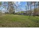 Expansive backyard features mature trees, a trampoline, green grass and a screened in porch at 3416 Cottonwood Dr, Durham, NC 27707