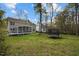 Large yard featuring mature trees, green grass, a trampoline, and a screened in porch and deck at 3416 Cottonwood Dr, Durham, NC 27707