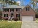 Charming red brick two-story home with an attached two-car garage and a well-manicured front lawn at 3416 Cottonwood Dr, Durham, NC 27707