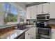 Bright kitchen features stone countertops, stainless appliances, and natural light at 3416 Cottonwood Dr, Durham, NC 27707