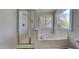 Bright bathroom featuring a separate shower and a luxurious soaking tub under a sunny window at 3501 Kensett Way, Raleigh, NC 27616
