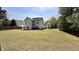 Spacious backyard featuring a gray two-story home and expansive lawn at 404 Braxman Ln, Holly Springs, NC 27540